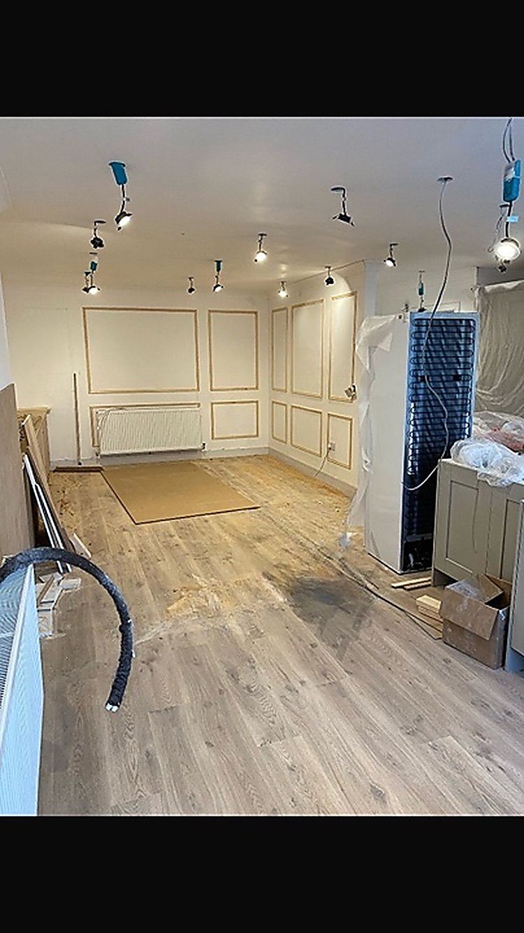 Wall panelling being fitted in an open-plan room