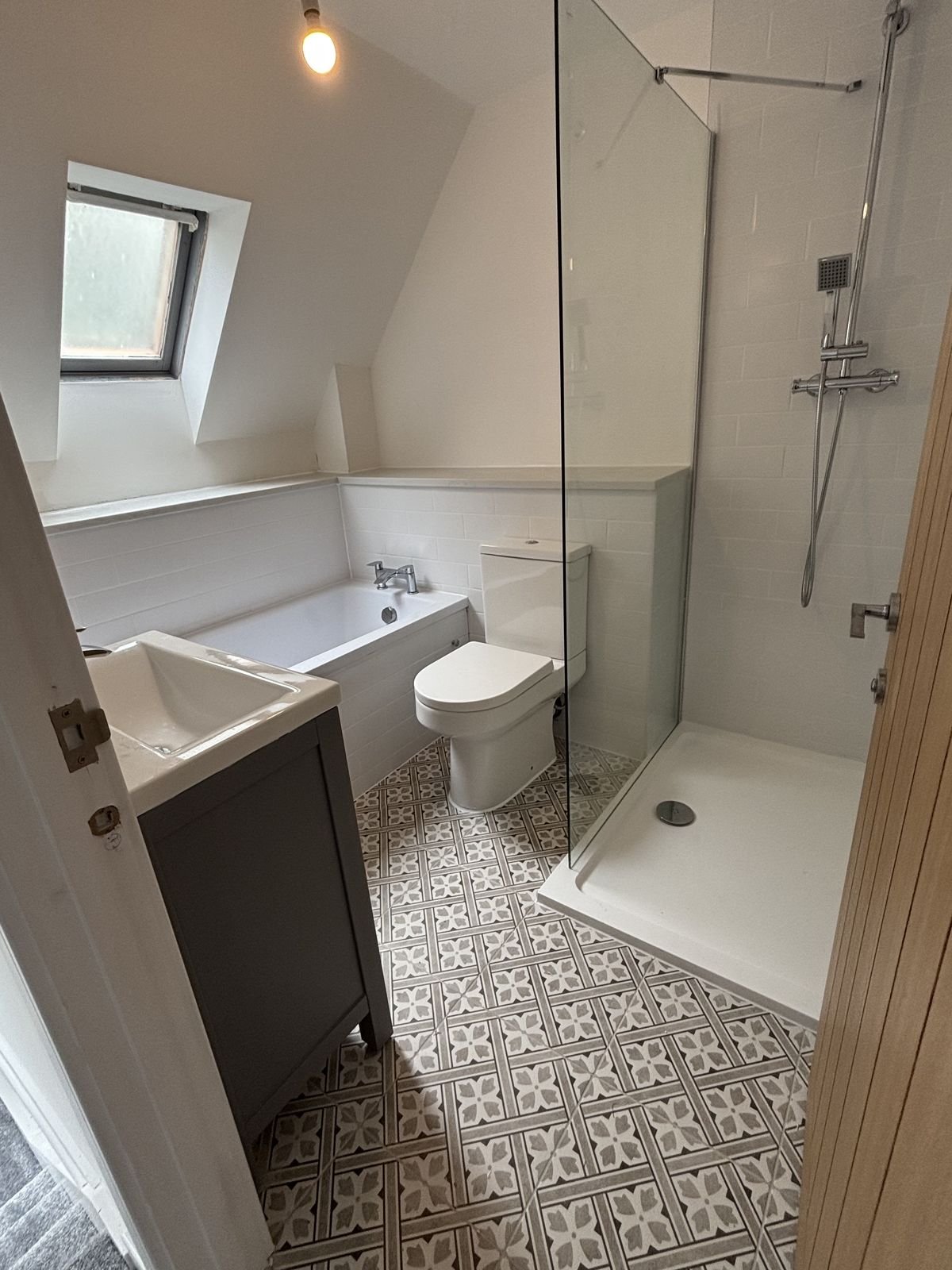 A loft bathroom with patterned floor tiles