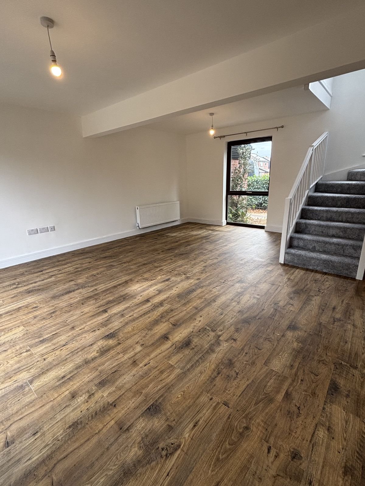 A living room with new flooring and a new staircase