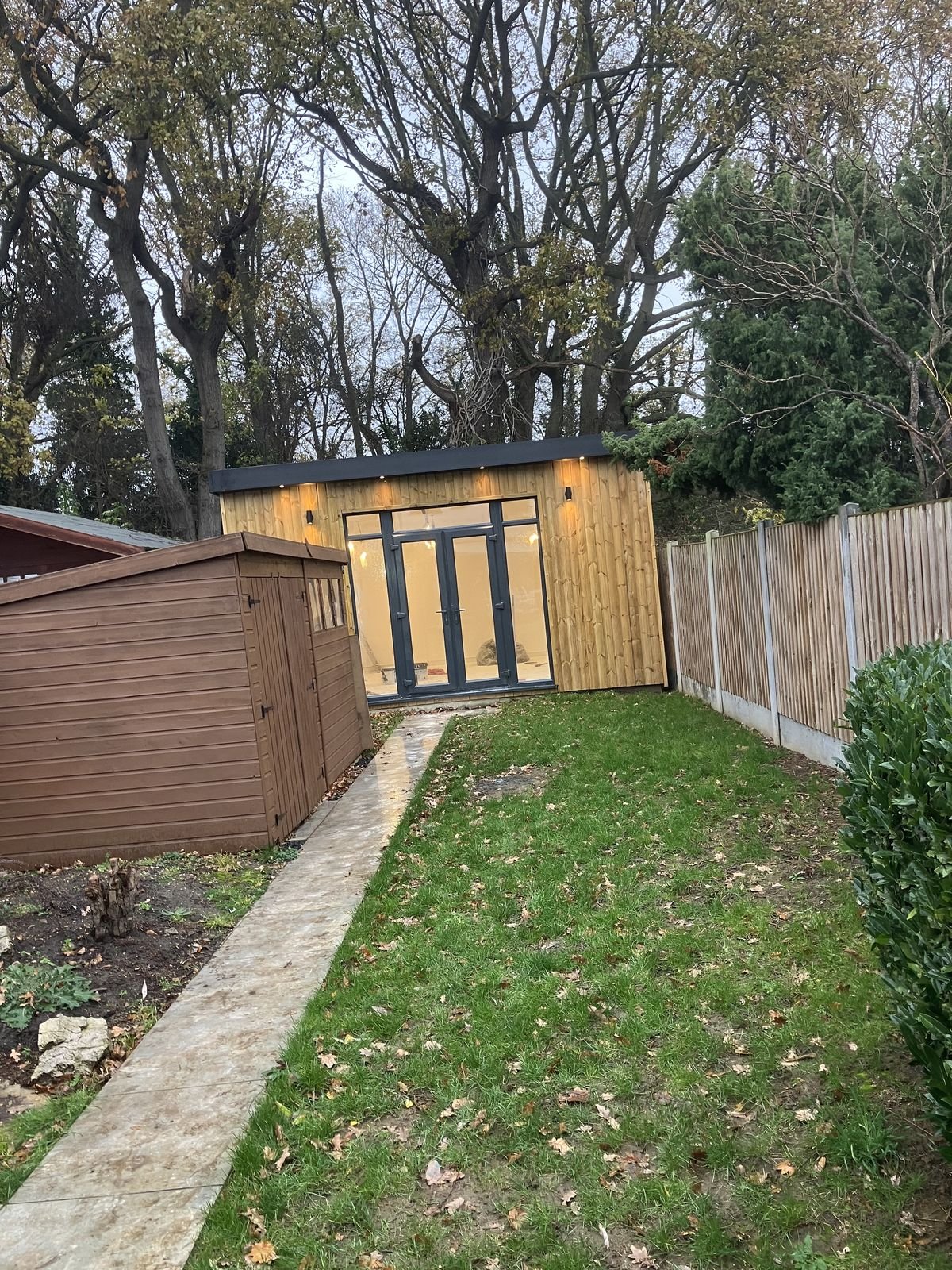 A timber clad garden room with dark French doors