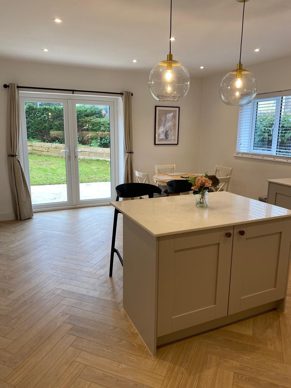 A kitchen island with a quartz top and pendant lights