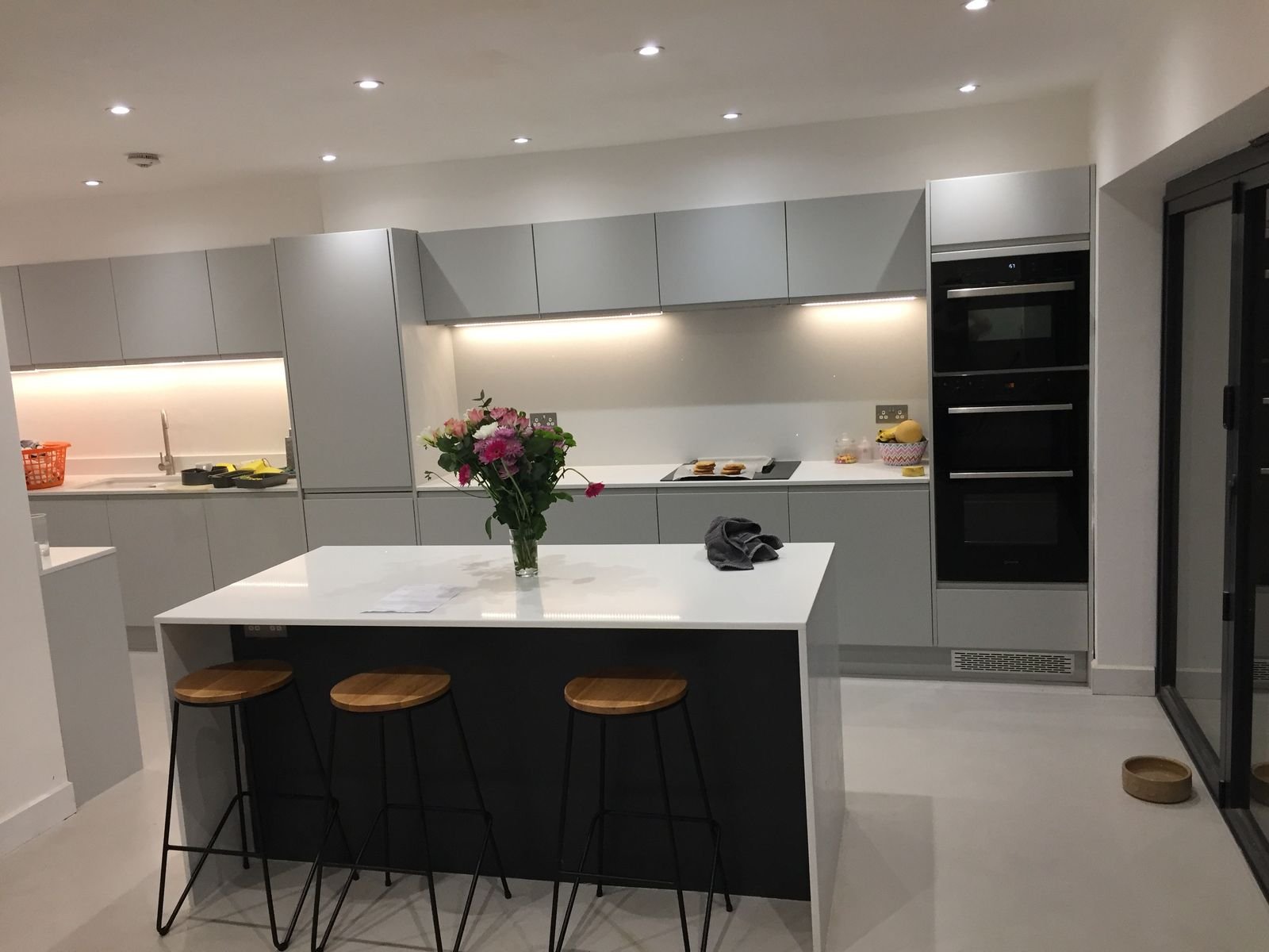 A handleless grey kitchen with tall ovens