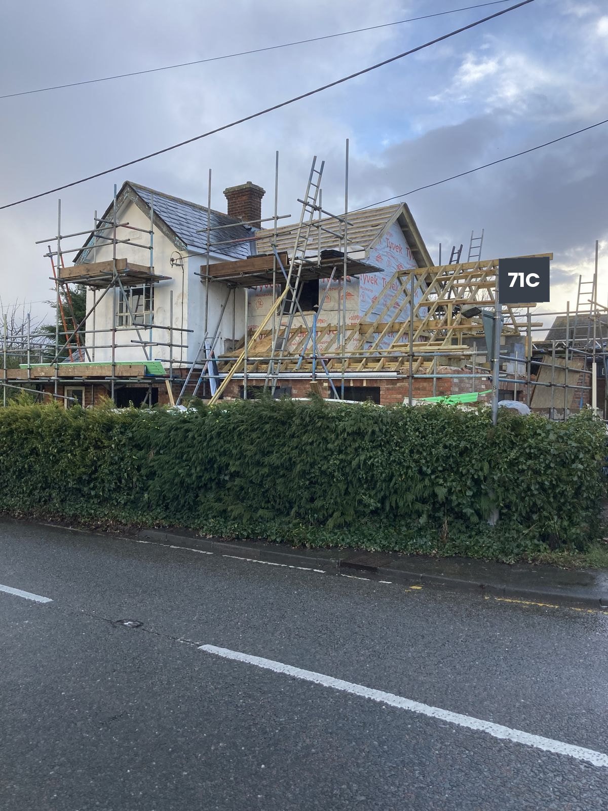 A house with scaffolding up and a new roof going on
